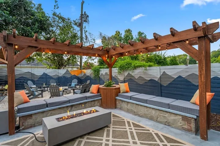 Staged outdoor patio with a pergola and gas fire table at a managed rental property.